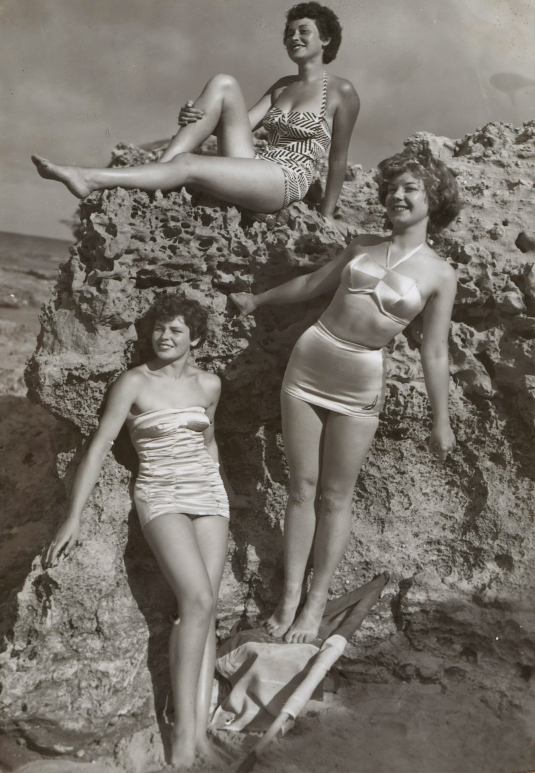 Bernice Kopple, Photograph used in article 'Bonny Scot Beach Girl', Australia,1950s by Audio Brands grayscale photo of three women standing and sitting on rocks