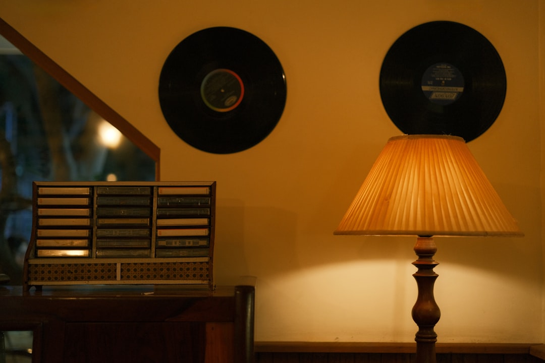 The Genesis of Sonic Excellence: A Brief History of High-End Loudspeakers by Audio Brands Records, lamp, and cassette player in cozy scene.