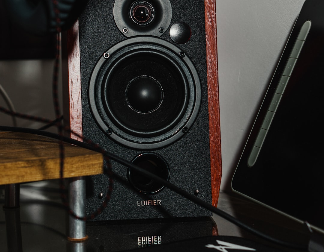 a speaker sitting on top of a table next to a laptop